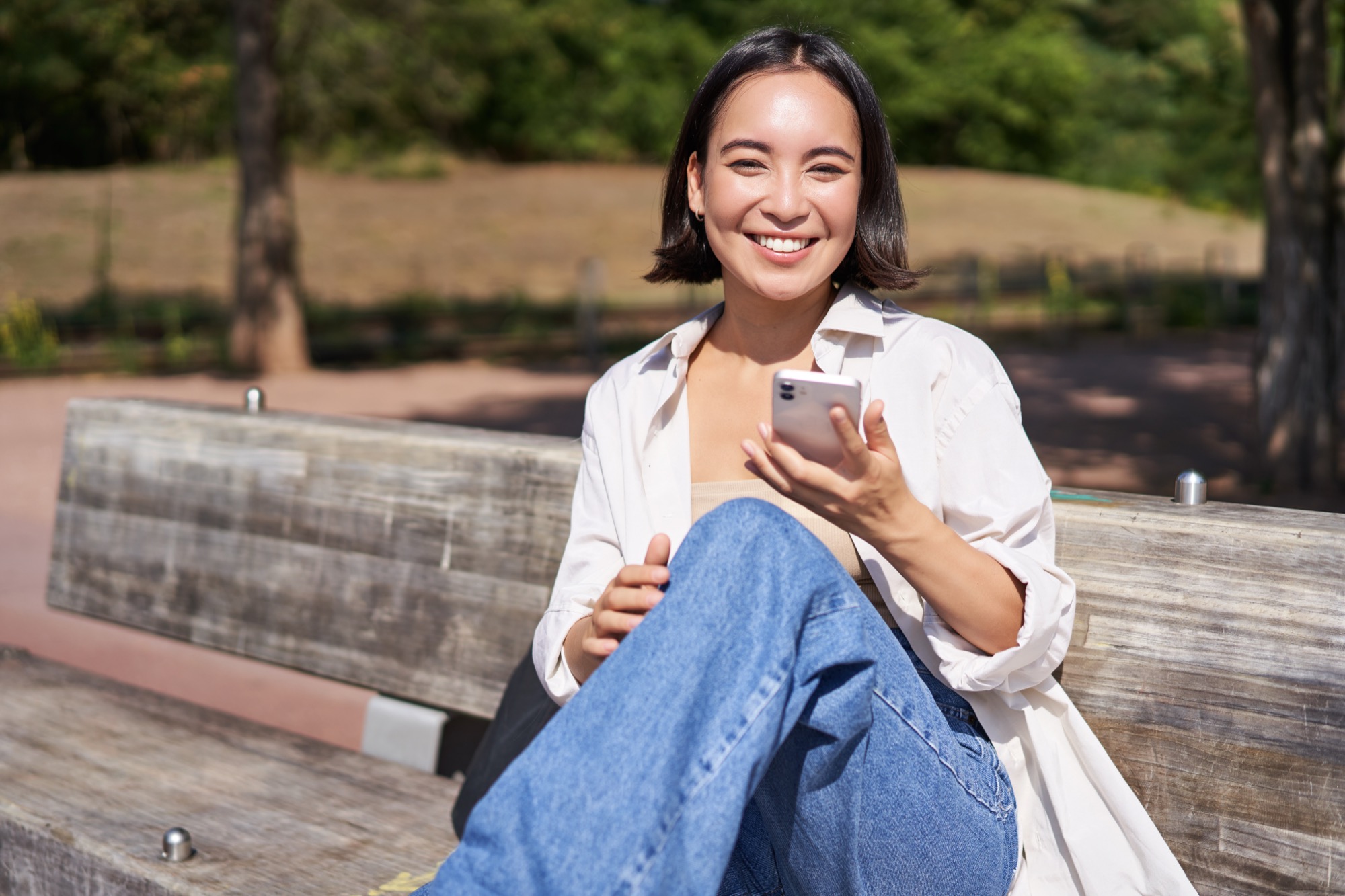 A woman smiling at her phone while using Abakus